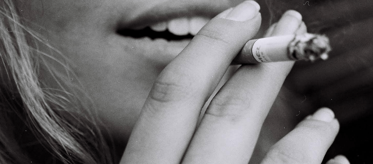 A woman holding a cigarette.
