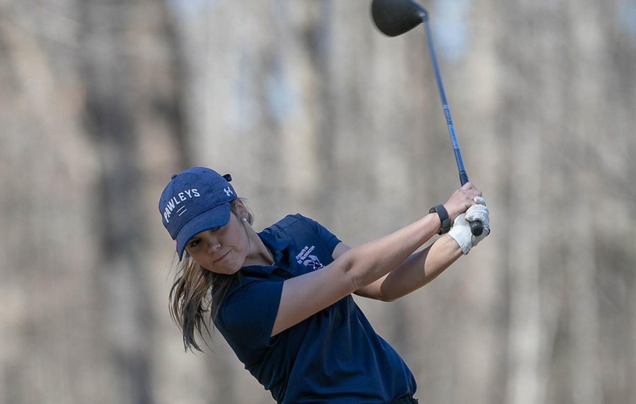 Andrea Dill a women's golf player swings her club in a tournament.
