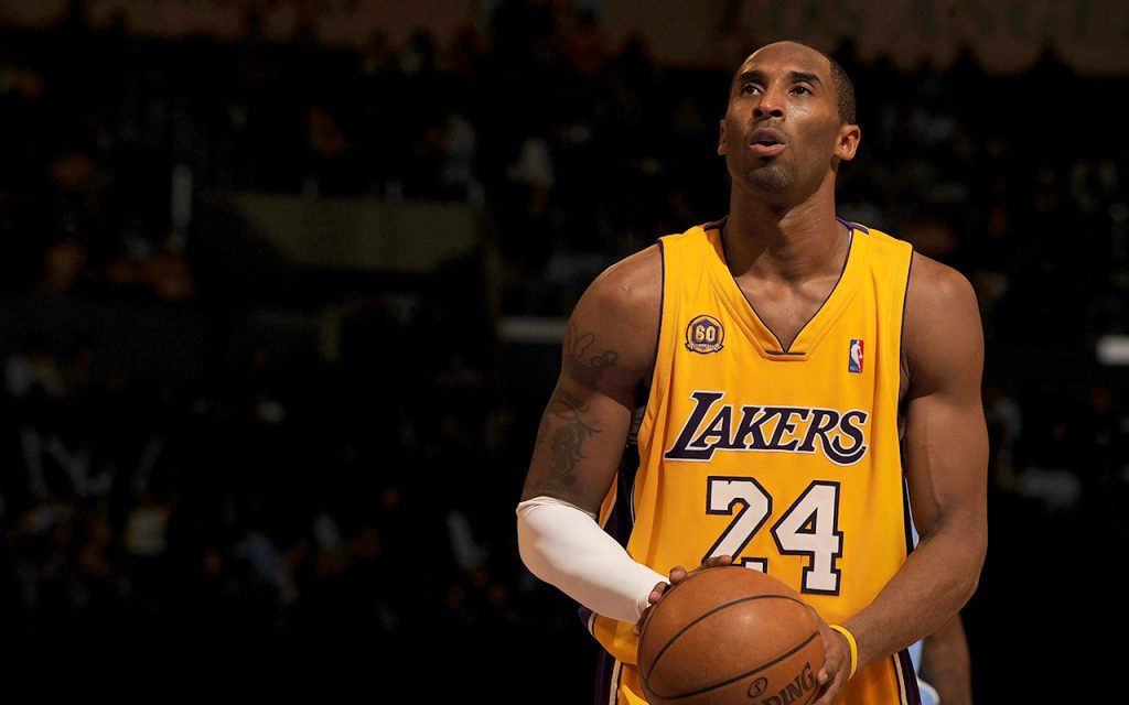 Kobe Bryant holds a basketball in his Laker's jersey