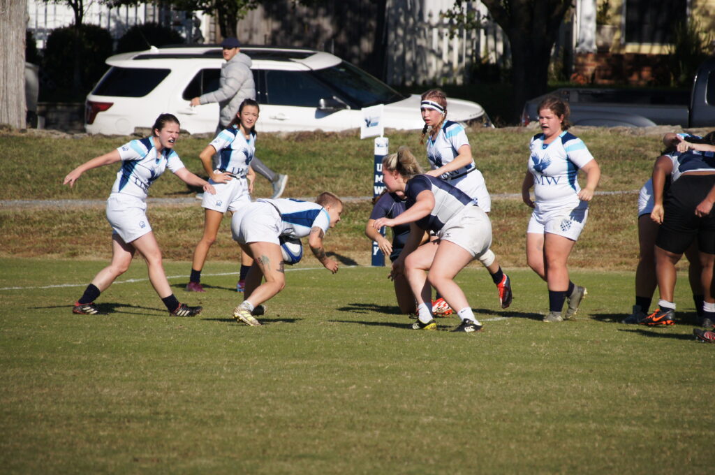 Female rugby players about to tackle.