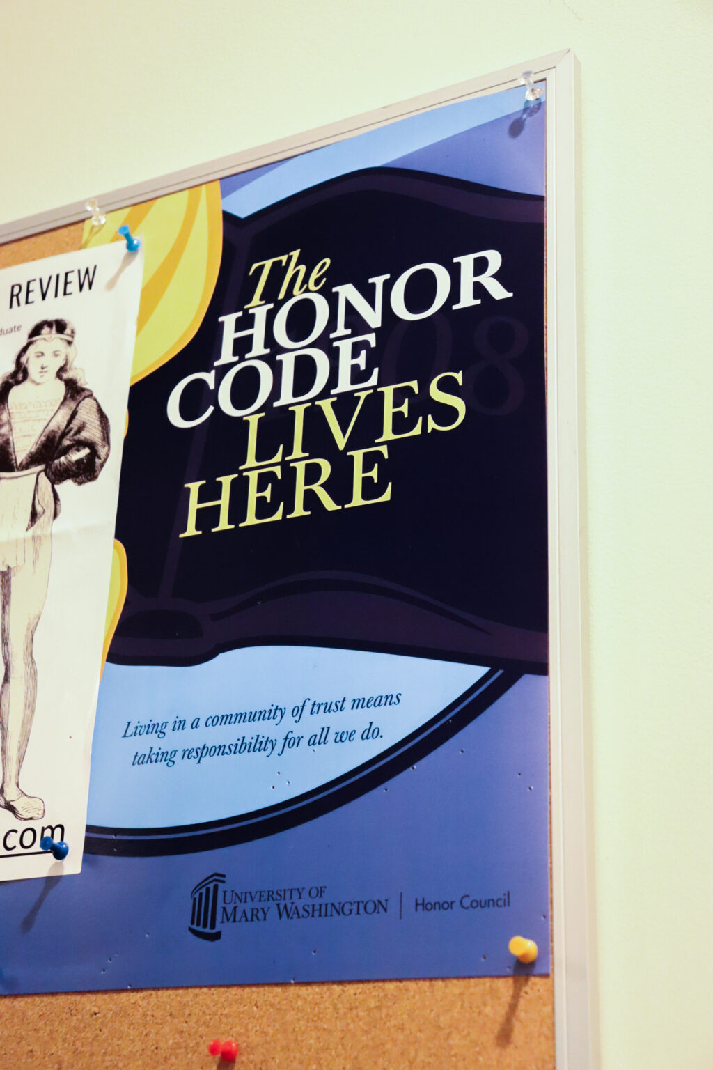 Picture of a blue poster on a corkboard. It reads, "The honor code lives here"