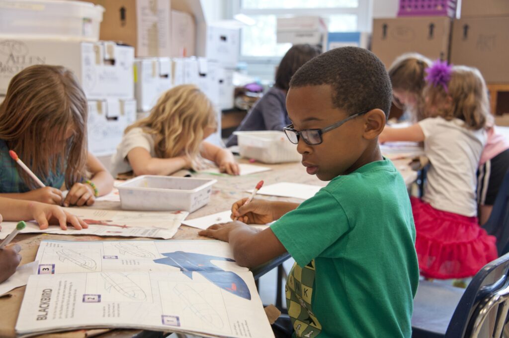Elementary school children doing homework in a classroom.