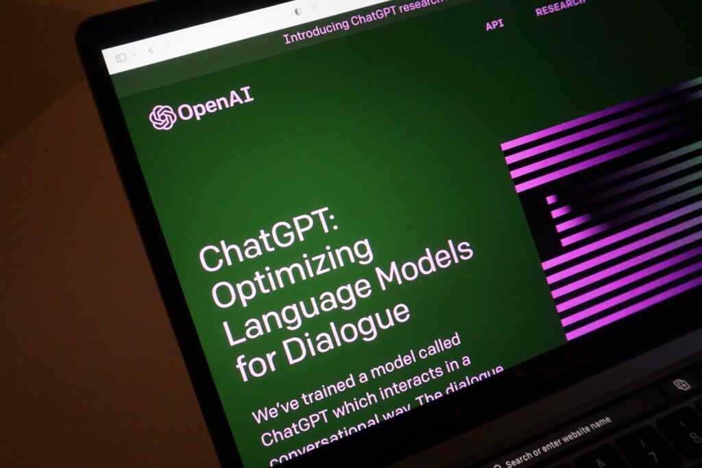 A computer screen shows a green and purple image that reads "ChatGPT: Optimizing Language Models for Dialogue"
