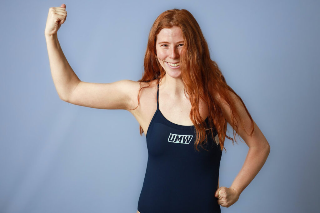 Girl in a swimsuit flexes her arm.