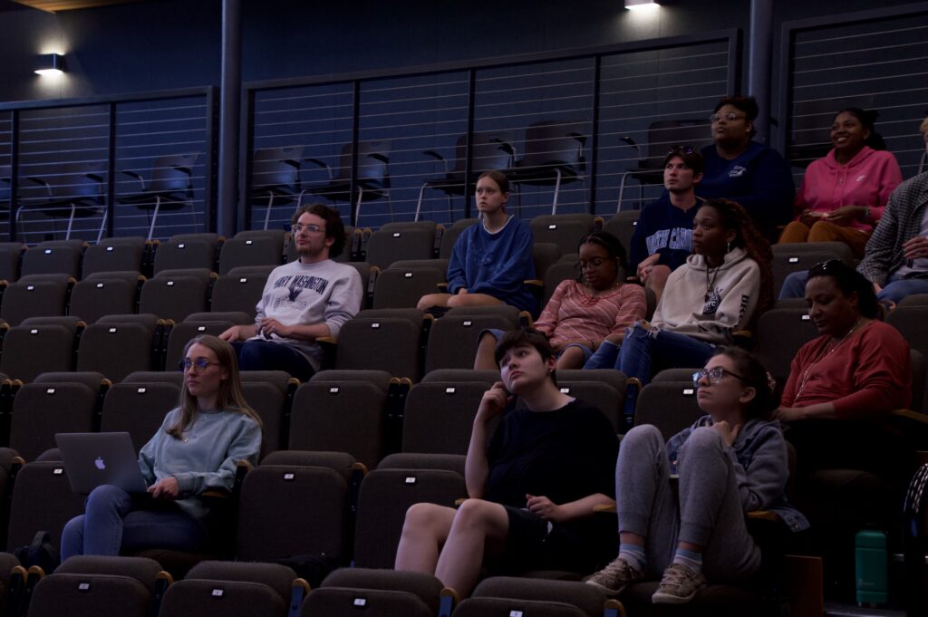 Students watch University President Troy Paino as he presents at the SGA Budget and Fee Setting Forum.