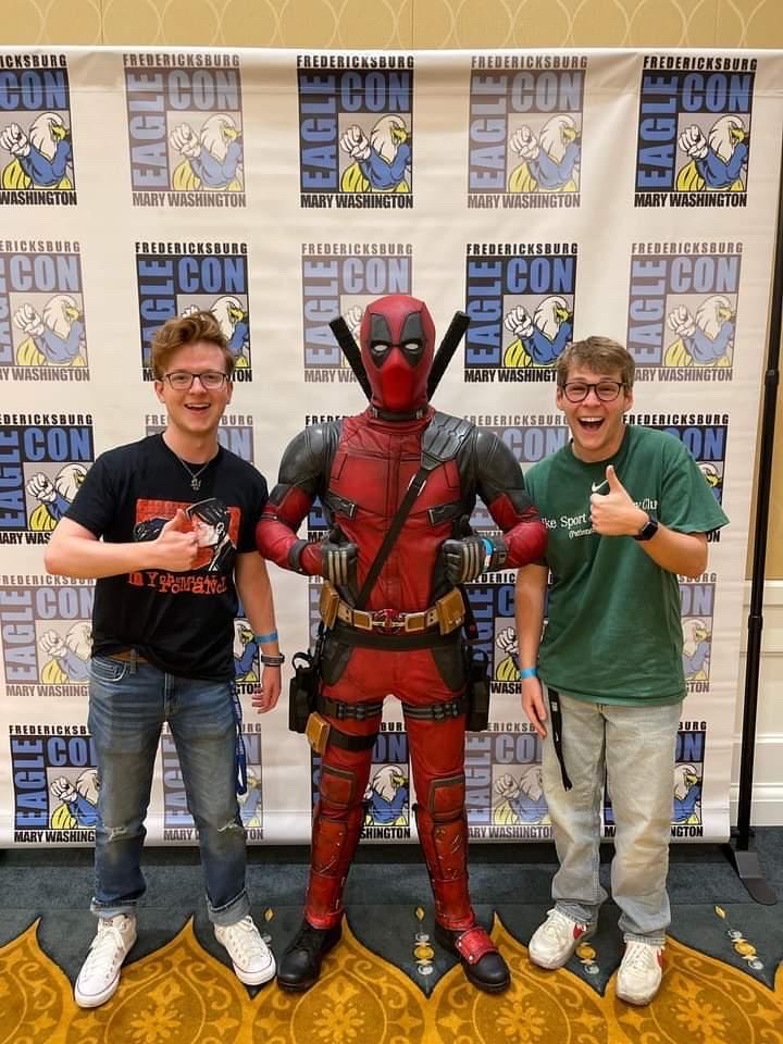Blake Bauer and Allen Queen gives a thumbs up with a smile while standing next to Chris Walker in a Deadpool costume.