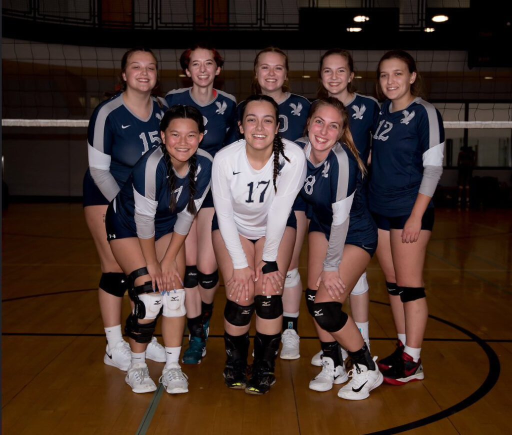 The UMW women's club volleyball poses for a team photo on the court. 