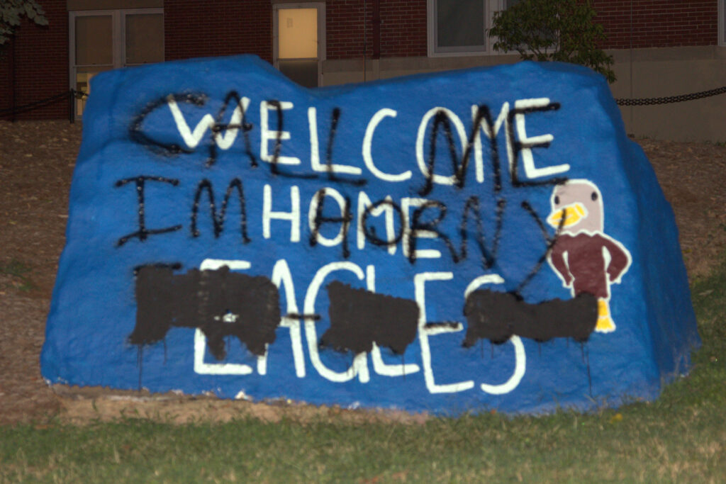 The spirit rock along Campus Walk with the white painted words of "Welcome Home Eagles" painted over with black paint stating, "CALL ME I'M HORNY" and a blurred out phone number