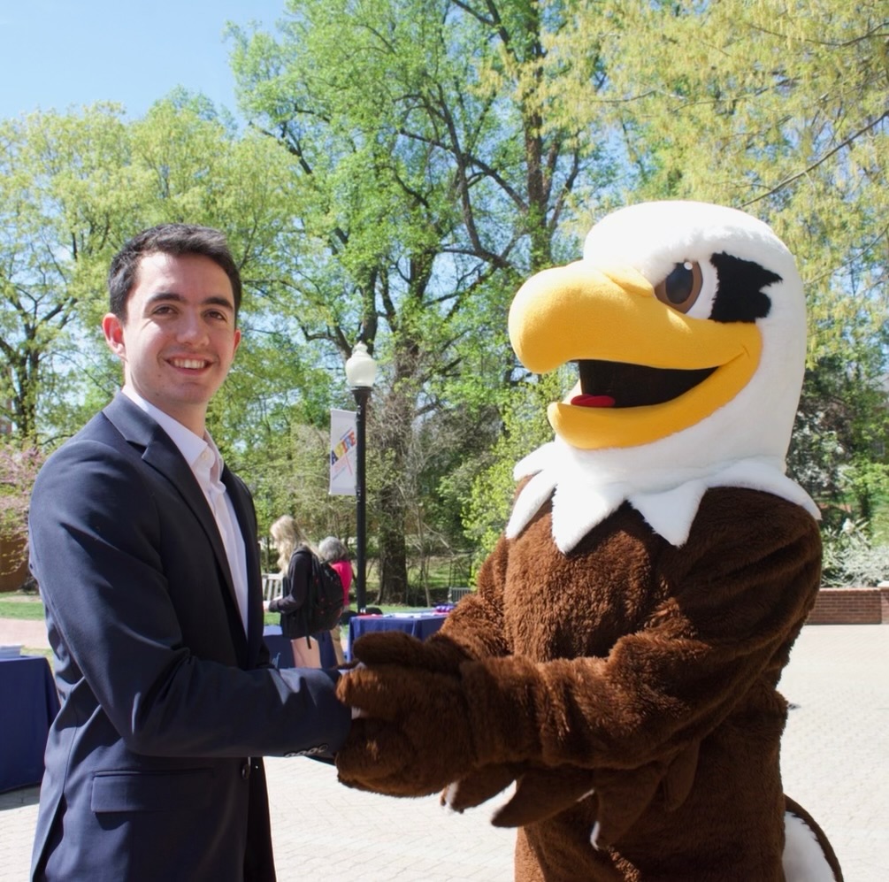 Devin Schwers smiles as he shake Sammy the Eagle's hand.