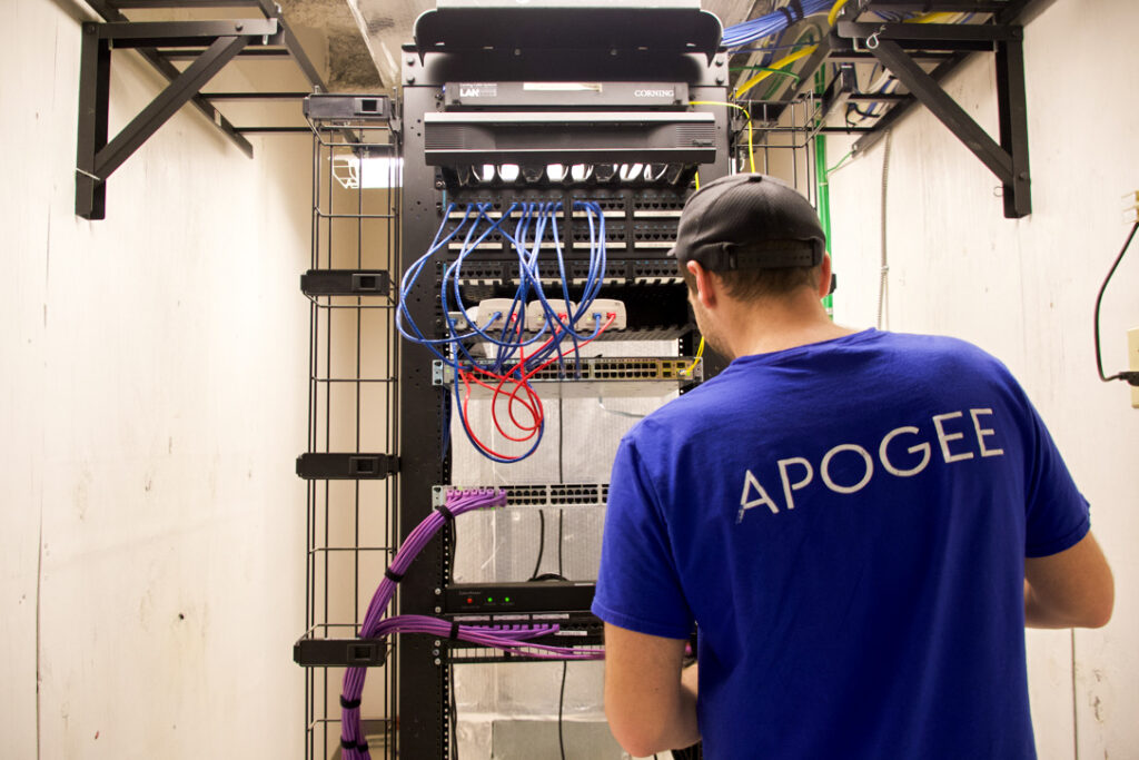An APOGEE employee wearing a blue shirt working the Wi-Fi machine