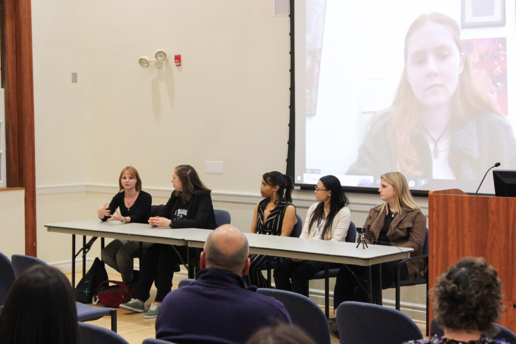 Jess Kirby speaking along with her hands while sitting next to Kate Seltzer, Mandy Byrd, Stella Swope, Emily Kaser and Michaela Daye.