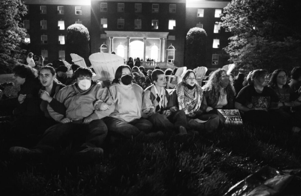 a black and white photo of students camping out together during a protest.