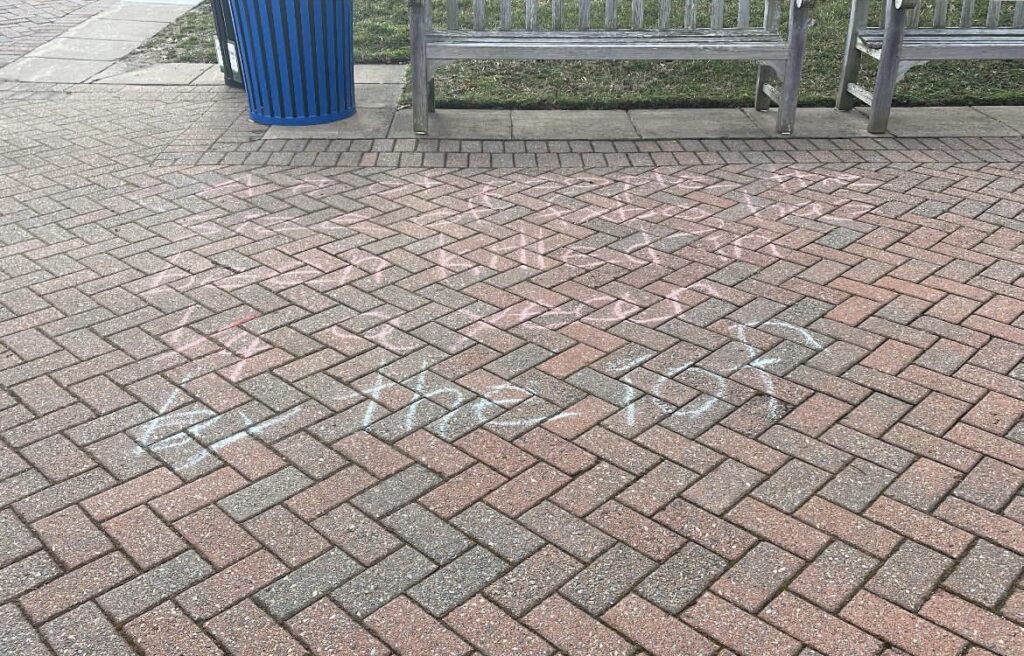 Photo of brick flooring with chalk writing.