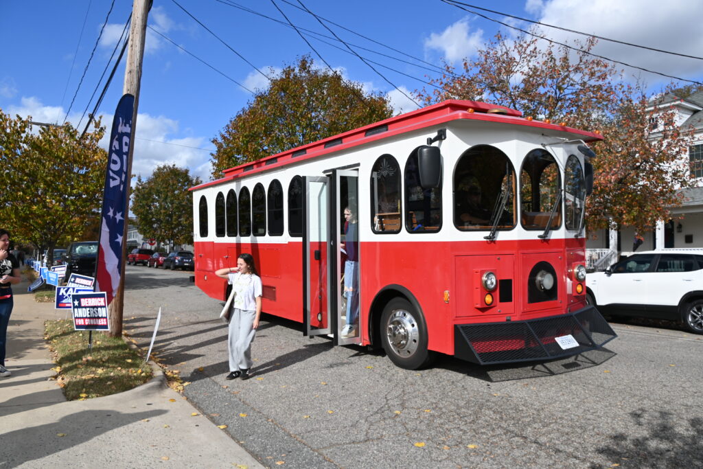 A red and white trolley stops as students get off at the polling place for UMW.