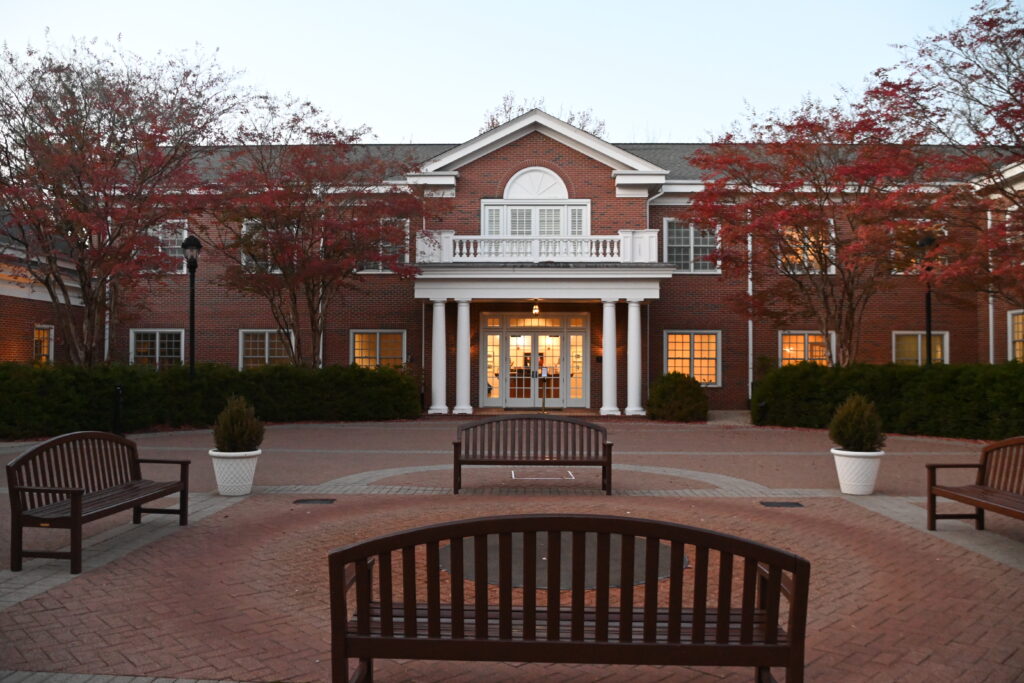 The front of the Jepson Alumni Executive Center with red trees in front.